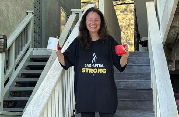 A woman wears a SAG-AFTRA Strong shirt while holding two coffee mugs in this image from Fran Drescher / Instagram