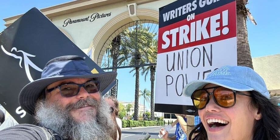 Two people hold protest signs in this image from Jack Black / Instagram